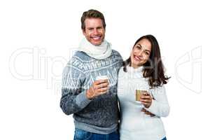 Festive couple smiling and holding mugs