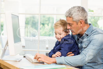 Father and son using the computer