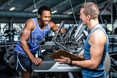 Muscular man discussing performance with trainer