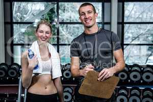 Male trainer and fit woman smiling