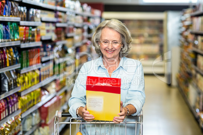 Smiling senior woman buying cereals Smiling senior woman buying cereals