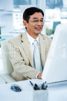 Smiling businessman using his computer