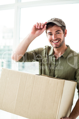 Smiling postman holding package
