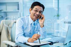 Smiling asian businessman calling someone