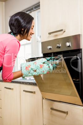 Smiling woman looking in the oven