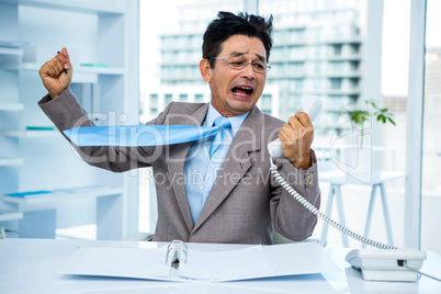 Businessman shouting as he holds out phone