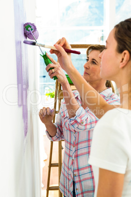 Mother and daughter focused on painting