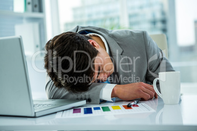 Asian businessman sleeping on his desk