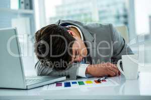 Asian businessman sleeping on his desk
