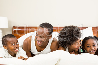 Cute family resting on bed