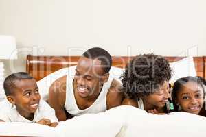 Cute family resting on bed