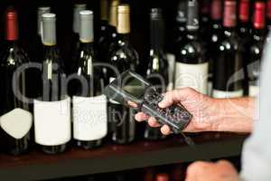 Senior man scanning wine bottles