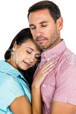 Peaceful couple hugging with eyes closed