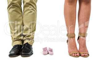 Close-up of man and woman amidst baby shoes