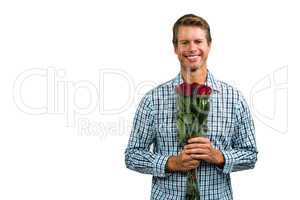 Portrait of smiling man holding bouquet of roses
