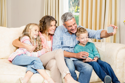 Family taking selfie on sofa