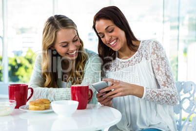 two girls watch a phone