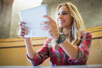 Smiling female student using tablet