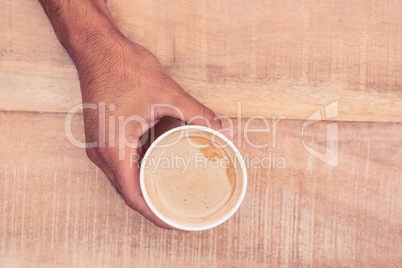 Cropped hand holding coffee cup