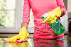 Midsection of woman cleaning the counter