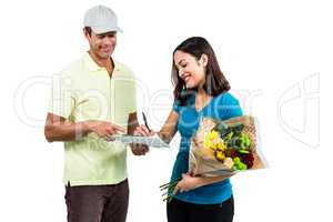 Woman signing on clipboard while receiving bouquet