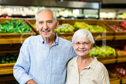 Smiling senior couple at the grocery shop