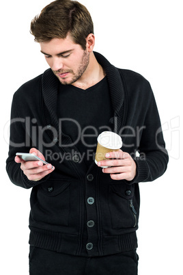 Handsome man using smartphone and holding disposable cup