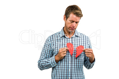 Portrait of sad man holding broken heart
