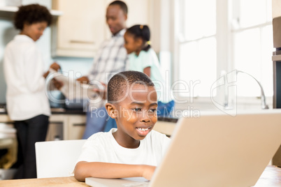 Son using laptop in the kitchen