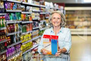 Smiling senior woman buying cereals