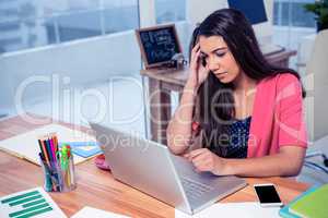 Stressed beautiful businesswoman using laptop