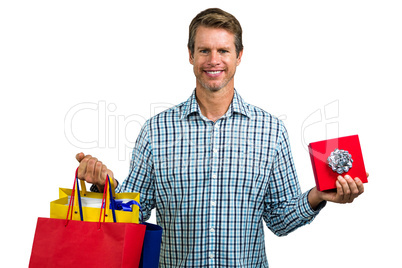 Happy man holding shopping bags and gift box