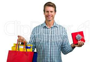 Happy man holding shopping bags and gift box