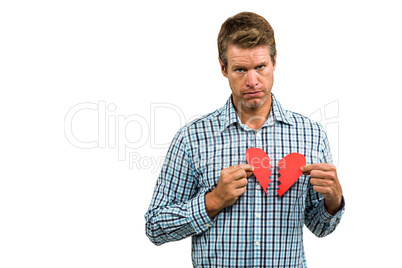 Portrait of sad man holding broken heart