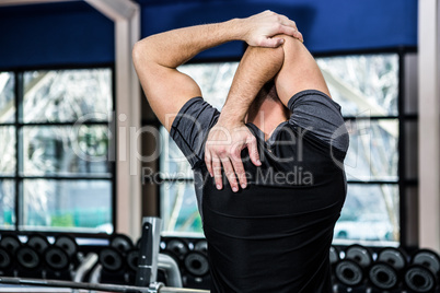 Rear view of man stretching arms