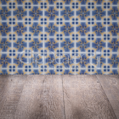 Wood table top and blur vintage ceramic tile pattern wall