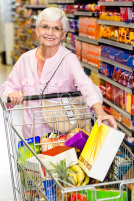 Smiling senior woman taking corn flakes box