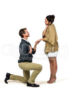 Handsome man proposing woman while kneeling