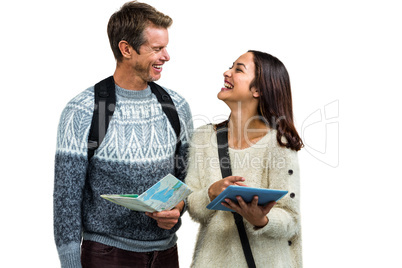 Happy couple with map and digital tablet while traveling