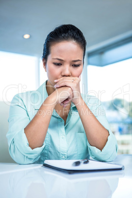 Thoughtful young businesswoman looking notes