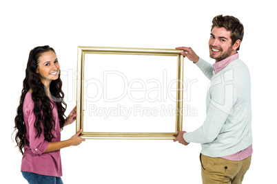 Smiling couple holding picture frame