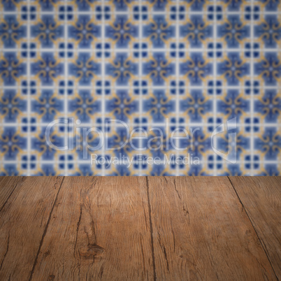 Wood table top and blur vintage ceramic tile pattern wall