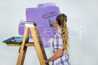 Casual woman painting a wall
