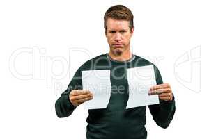 Portrait of serious man holding torn documents