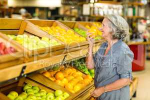 Smiling senior woman smelling orange