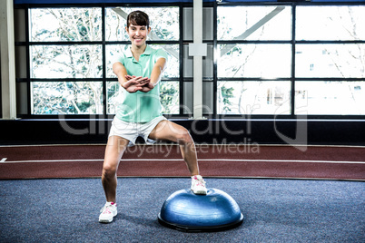 Fit woman doing exercise with bosu ball