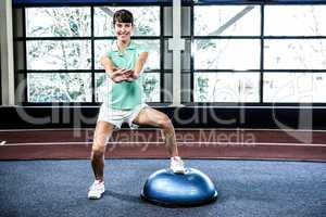 Fit woman doing exercise with bosu ball