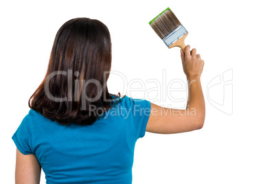 Rear view of woman holding paint brush
