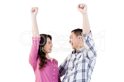 Cheerful young couple with hands raised