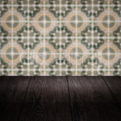 Wood table top and blur vintage ceramic tile pattern wall